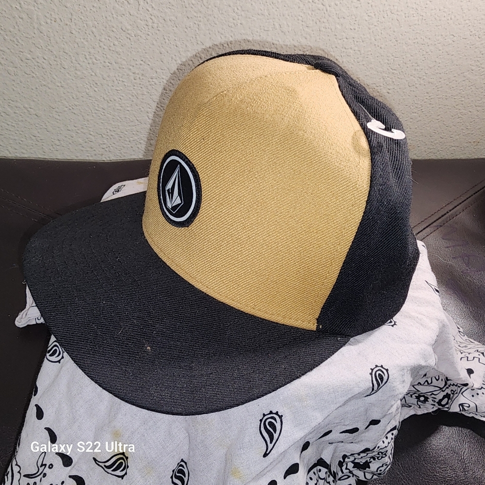 Tan and black volcom snap back hat
